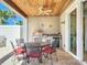 A covered outdoor patio with a dining table, chairs, stainless steel appliances, and sliding glass doors at 1204 Derby Ln, Sarasota, FL 34242
