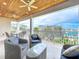 A large covered patio has tiled flooring, outdoor seating, views of the water, and ceiling fans at 1204 Derby Ln, Sarasota, FL 34242