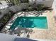 An aerial view of a beautiful in-ground pool, surrounded by a brick patio and lush tropical landscaping at 1204 Derby Ln, Sarasota, FL 34242