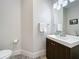 A convenient half-bathroom features modern fixtures, wood cabinet and elegant lighting at 1204 Derby Ln, Sarasota, FL 34242