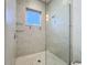 Bright shower featuring tiled walls, glass door, and a window for natural light, creating a clean and refreshing space at 1204 Derby Ln, Sarasota, FL 34242