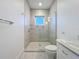 Modern shower with glass enclosure, tiled walls, and a window for natural light, offering a spa-like experience at 1204 Derby Ln, Sarasota, FL 34242