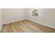 Empty bedroom featuring wood look floors, neutral walls, and a bright window at 1206 E Osborne Ave, Tampa, FL 33603