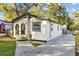 Charming single-story home featuring an arched entryway, fresh landscaping, and a concrete driveway at 1206 E Osborne Ave, Tampa, FL 33603