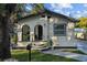 Charming single-story home featuring an arched entryway, fresh landscaping, and inviting curb appeal at 1206 E Osborne Ave, Tampa, FL 33603
