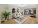 Bright living room featuring a white sofa, modern flooring, and an open layout to the kitchen at 1206 E Osborne Ave, Tampa, FL 33603