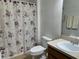 Cozy bathroom featuring a floral shower curtain, toilet and sink at 15421 Shoal Haven Pl, Ruskin, FL 33573