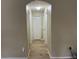 Bright hallway with wood-look tile floors leading to bedrooms and closets at 15421 Shoal Haven Pl, Ruskin, FL 33573