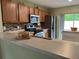 Well-equipped kitchen featuring stainless steel appliances, wood cabinets and mosaic tile backsplash at 15421 Shoal Haven Pl, Ruskin, FL 33573