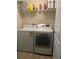 Modern laundry room equipped with a washer, dryer, and plenty of storage shelves at 15421 Shoal Haven Pl, Ruskin, FL 33573