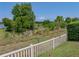 Green backyard with white fencing and a view of foliage, creating a private outdoor space at 1701 Bonita Bluff Ct, Ruskin, FL 33570