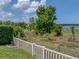 Backyard with a white fence and green space, offering a peaceful outdoor view with lots of foliage at 1701 Bonita Bluff Ct, Ruskin, FL 33570