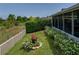 Well-maintained backyard featuring lush greenery, flower beds, and a screened-in lanai for outdoor relaxation at 1701 Bonita Bluff Ct, Ruskin, FL 33570