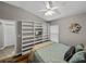 Bright bedroom featuring built-in shelving, wood floors, and a ceiling fan at 1701 Bonita Bluff Ct, Ruskin, FL 33570