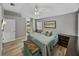 Comfortable bedroom with neutral paint, wood floors, and ensuite bathroom at 1701 Bonita Bluff Ct, Ruskin, FL 33570