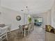 Light-filled dining room with a wooden table, white chairs, and a view of the screened outdoor living area at 1701 Bonita Bluff Ct, Ruskin, FL 33570