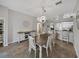 Dining room featuring a wooden table, white chairs, and a decorative sideboard, with views to the kitchen at 1701 Bonita Bluff Ct, Ruskin, FL 33570