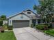 Charming single-story home featuring a two-car garage, covered porch, and manicured landscaping at 1701 Bonita Bluff Ct, Ruskin, FL 33570