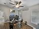 Well-lit home office with multiple monitors, hardwood floors, and a ceiling fan at 1701 Bonita Bluff Ct, Ruskin, FL 33570