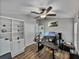 A well-lit office space boasts a large desk, multiple monitors, built-in shelving and wood flooring at 1701 Bonita Bluff Ct, Ruskin, FL 33570
