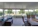 Enclosed porch with cushioned sofa seating and view of green landscape and partial lake view at 1701 Bonita Bluff Ct, Ruskin, FL 33570