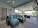 Enclosed porch with comfortable cushioned seating area overlooking green landscape and partial water views at 1701 Bonita Bluff Ct, Ruskin, FL 33570