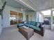 Cushioned sofa seating area in enclosed patio with partial water views and ceiling fan at 1701 Bonita Bluff Ct, Ruskin, FL 33570