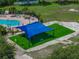 Aerial view of a playground with swings, slides, and a shade cover, next to the community pool at 1701 Bonita Bluff Ct, Ruskin, FL 33570