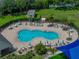 Aerial shot of a community pool surrounded by lounge chairs, tables, and umbrellas at 1701 Bonita Bluff Ct, Ruskin, FL 33570