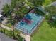 Aerial view of a fenced tennis court with a red and green playing surface at 1701 Bonita Bluff Ct, Ruskin, FL 33570