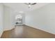 Airy bedroom featuring wood floors, modern fan, and an arched window to let in natural light at 1729 Arabian Ln, Palm Harbor, FL 34685