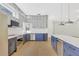 Modern kitchen with two-tone cabinets, stainless steel appliances, stylish pendant lights, and a wine fridge enhancing the functionality at 1729 Arabian Ln, Palm Harbor, FL 34685