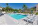 Community pool and leisure area with plenty of lounge chairs, tables, and lush landscaping at 1729 Arabian Ln, Palm Harbor, FL 34685