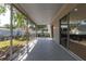 Covered porch area with views of the lush backyard, accessible through sliding glass doors, enhancing the indoor-outdoor living at 1729 Arabian Ln, Palm Harbor, FL 34685