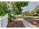 Secluded backyard with brick pathway, garden bed, and white picket fence at 17631 Grove View Dr, Lutz, FL 33549