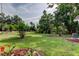 Expansive backyard featuring lush lawn, mature trees, and landscaped beds at 17631 Grove View Dr, Lutz, FL 33549