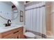 Cozy bathroom featuring a vanity with modern fixtures and a shower with a white curtain at 17631 Grove View Dr, Lutz, FL 33549