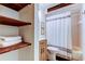 Bathroom with a shower, vanity, and open shelving showcasing stylish decor and organized storage at 17631 Grove View Dr, Lutz, FL 33549