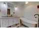 Bright bathroom with a white vanity, quartz countertop, and a freestanding vintage bathtub at 17631 Grove View Dr, Lutz, FL 33549