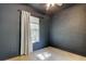 Bedroom featuring a window with natural light, dark walls, and neutral tile flooring at 17631 Grove View Dr, Lutz, FL 33549