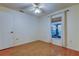 Simple bedroom features a ceiling fan, window, and door creating a blank canvas for personalization at 17631 Grove View Dr, Lutz, FL 33549