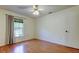 Bright, empty bedroom with hardwood floors, a ceiling fan, and natural light from a window at 17631 Grove View Dr, Lutz, FL 33549