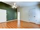 Bright bedroom with wood floors, neutral walls, fan, and ensuite bathroom at 17631 Grove View Dr, Lutz, FL 33549