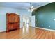 Bedroom with wood floors and ceiling fan, with a peek at another room through open doors at 17631 Grove View Dr, Lutz, FL 33549