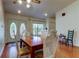 Dining room with wood floors, chandelier lighting, and a view of the glass door entrance at 17631 Grove View Dr, Lutz, FL 33549