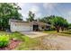 A charming ranch style home with an American flag, mature trees and a 2-car garage at 17631 Grove View Dr, Lutz, FL 33549