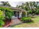 Front entrance with a brick walkway, tropical landscaping and double doors at 17631 Grove View Dr, Lutz, FL 33549