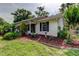 Charming home featuring a well-manicured lawn, flowerbeds, and dark window shutters at 17631 Grove View Dr, Lutz, FL 33549