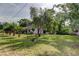 Home with a large lawn, mature trees, and a classic white picket fence creating a peaceful setting at 17631 Grove View Dr, Lutz, FL 33549