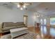 Bright and spacious living room with a modern sofa, hardwood floors, and a vaulted ceiling at 17631 Grove View Dr, Lutz, FL 33549